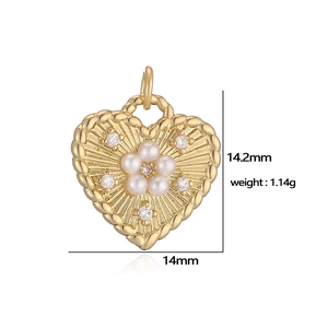 Detailed view of heart-shaped gold pendant with pearl flowers and sparkling crystals