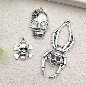 Macro detail of antique silver alloy skull and spider charms for DIY jewelry making