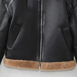 Détail d'une veste en cuir noir avec fermeture éclair en métal et bordure en fourrure