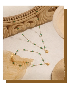 Detailed close-up of shell charms and green beads on a gold-plated vintage style necklace