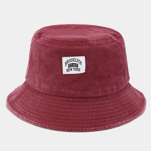 Détail d'un bob en toile lavée vintage rouge foncé avec écusson Brooklyn brodé dessus