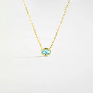 Detailed view of the gold S925 silver necklace with an oval light blue glass stone pendant