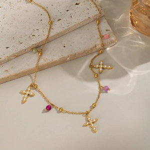 Detail of 18K gold stainless steel necklace with crystal crosses and colorful beads