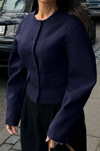 Street style view of a navy blue cropped vest with round neck and flap pockets