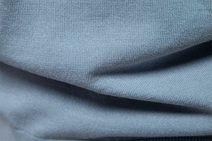Macro view of blue knitted fabric texture and fine stitch details on the polo shirt