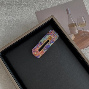 Detail view of rectangular marble texture hair clip on elegant black display tray
