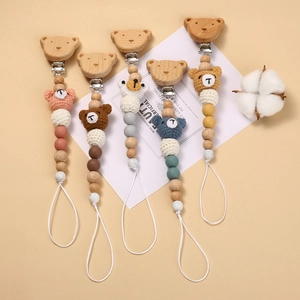 Detail of five crochet bear pacifier clips with wooden beads in various pastel colors