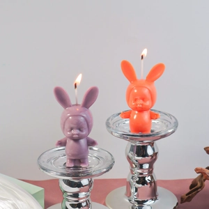 Detailed view of sleeping baby rabbit scented candles in purple and orange wax