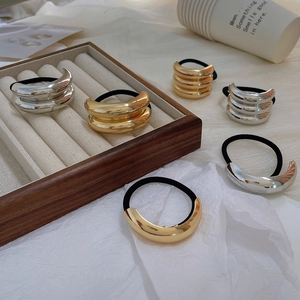 Minimalist metallic hair ties in gold and silver finish with smooth curved tube design