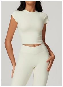 Dettaglio del top sportivo corto bianco crema e leggings yoga con vita a croce a V