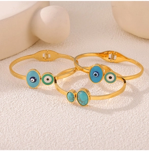 Close-up of bohemian titanium steel bangles with evil eye enamel and turquoise inlay