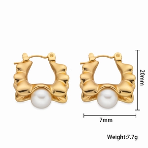 Detail view of wavy gold hoop earrings with white pearls, height 20mm and width 7mm
