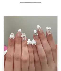 Detail of JP4014 nude pink french tip nails with 3D white bows and pearl accents