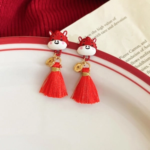 Detailed shot of red Chinese New Year pony earrings with gold coins and silk tassels