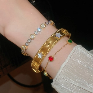 Detailed shot of gold flower bangles with mother of pearl and colorful gemstones