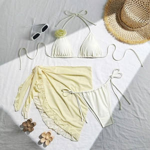 Detailed view of cream three-piece bikini set with 3D floral accents and mesh skirt
