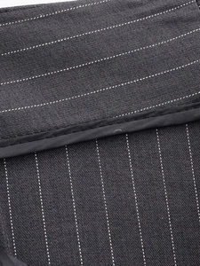 Détail macro du tissu gris foncé avec rayures pointillées blanches et coutures précises