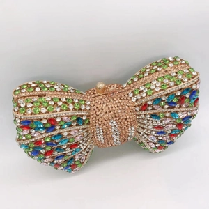 Close-up of sparkling colorful and clear rhinestones on golden bow evening clutch bag