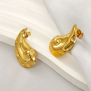 Hammered 18K gold-plated titanium heart earrings with elegant molten texture on silk