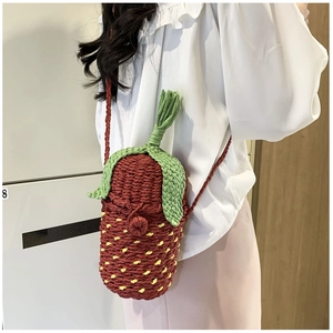 Detailed macro view of handmade woven strawberry-shaped bucket bag with green leaf top