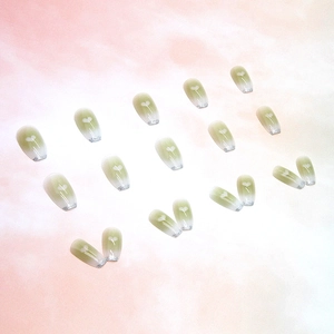 Faux ongles dégradé vert avec motifs cœurs blancs et paillettes argentées aux pointes