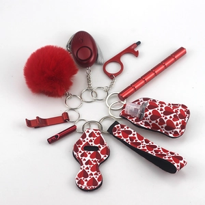 Detail view of a 10-piece red self-defense keychain set with plush pompom and alarm