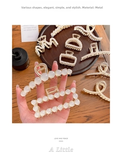 Detailed view of champagne gold metal hair claws with elegant white pearl embellishments