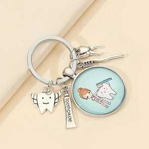 Detailed dental-themed keychain featuring a toothbrush, toothpaste, and cartoon tooth charms