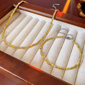 Close-up of gold and silver plated twist necklace and bracelet set in wooden jewelry box