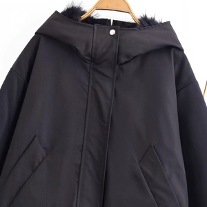 Women's black hooded parka jacket with faux fur trim and silver snaps on white background
