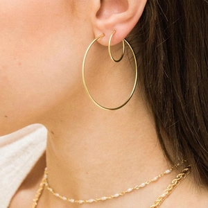Set of 925 sterling silver hoop earrings and layered gold pearl necklaces on model