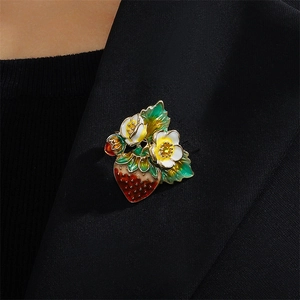 Enamel strawberry brooch with white flowers on a black blazer lapel for women