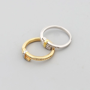 Macro shot of gold and silver nail rings with pave zircon settings and metal texture