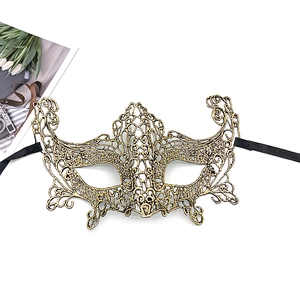 Close-up of gold lace masquerade mask with ornate baroque patterns and black ribbon ties