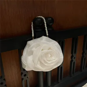 Detailed view of white 3D organza rose bag with elegant pearl beaded handle