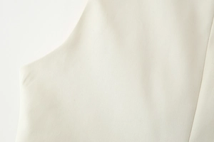 Detailed close-up showing the cream-white twill fabric texture and shoulder stitching