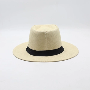 Close-up of a woven Panama straw hat with a black ribbon band on a white background