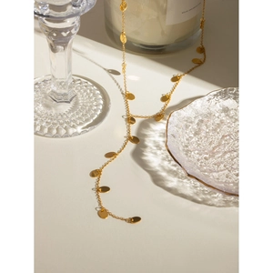 Detail of 18k gold plated stainless steel Y-necklace with diamond tassels on off-white