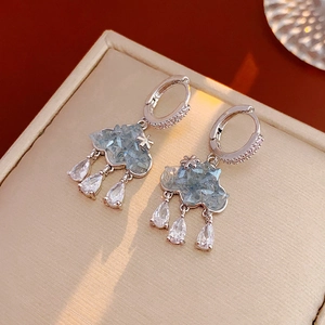 Détails macro des boucles d'oreilles nuage en argent avec zircons et gouttes de cristal