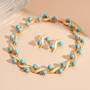 Golden geometric jewelry set with turquoise beads and necklace and earrings on peach background