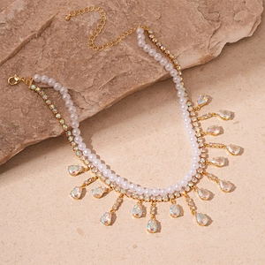 Macro view of double-layer pearl necklace with teardrop crystals on natural stone