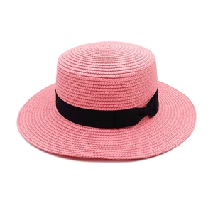 Detailed view of the pink boater hat with a chic black ribbon and elegant side bow