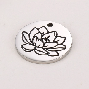 Detail view of round stainless steel pendant with engraved lotus flower and silver finish