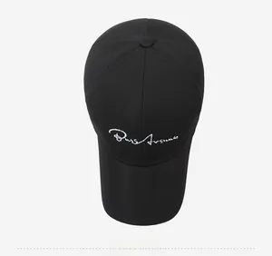 Top view of a black baseball cap featuring white embroidered artistic lettering on front