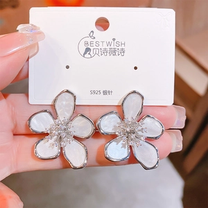 Detailed close-up of white five-petal flower stud earrings with S925 silver needle and zircons