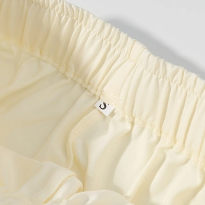Dettaglio della vita elastica e delle cuciture sottili su un capo in maglia beige