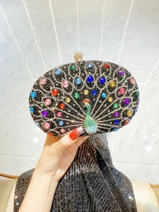 Close-up of a peacock evening clutch bag with colorful rhinestones on black oval shell