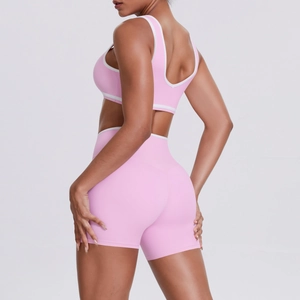 Detail of pink yoga set showing criss-cross waist shorts and contrast binding racerback top