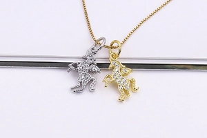 Dettaglio di ciondoli a unicorno in argento e oro con incastonatura pavé di zirconi