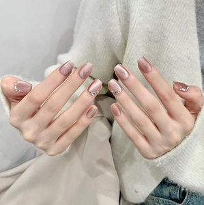 Handmade cat-eye press-on nails in dusty rose pink with glitter rhinestones